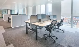 een ergonomische werkplek met ergonomische bureaustoel, zit-sta bureau en monitorarmen